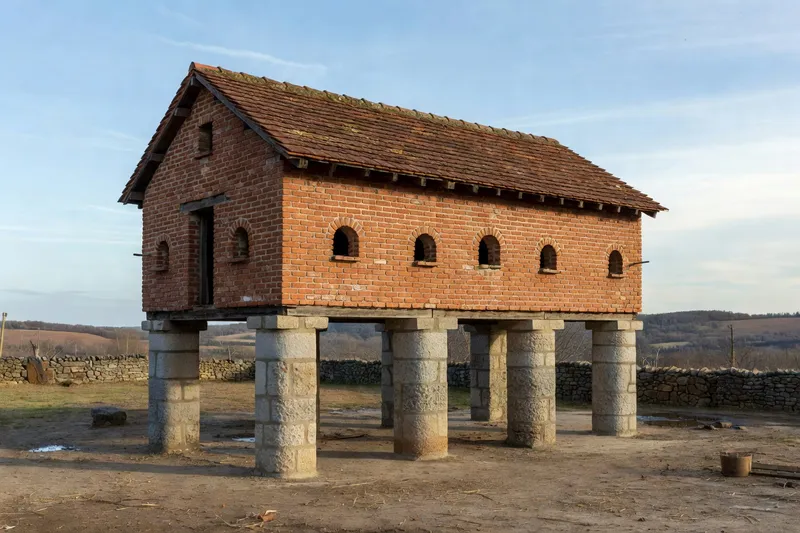 Pigeonnier sur piliers en brique dans une cour rurale du Lauragais.